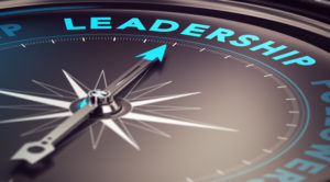 Compass with needle pointing the word leadership with blur effect plus blue and black tones. Conceptual image for illustration of leader motivation